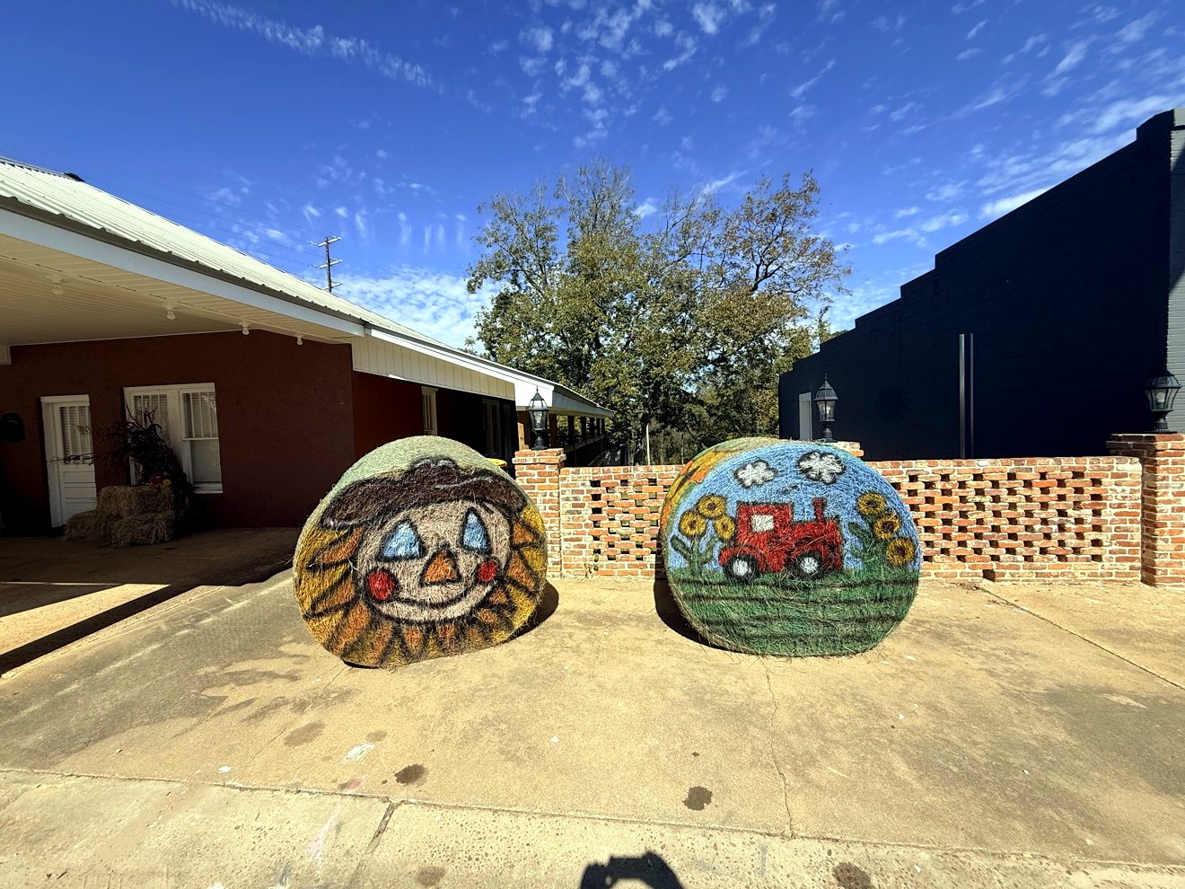 Two hay bales painted with a scarecrow and a tractor on Main Street in Ariton